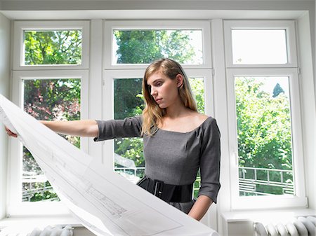 female and studying and window - Woman holding blue prints Stock Photo - Premium Royalty-Free, Code: 649-03666395