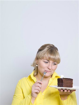 woman looking at plate of cake Stock Photo - Premium Royalty-Free, Code: 649-03666827