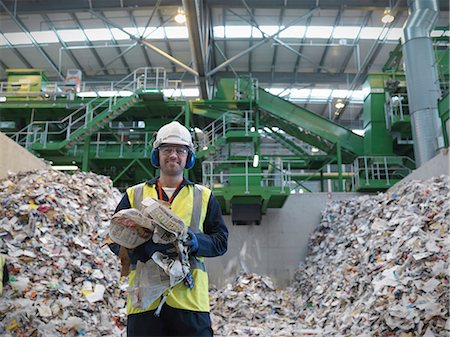 Worker With Paper Being Recycled Stock Photo - Premium Royalty-Free, Code: 649-03666892