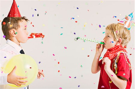 party boys blowing party blowers Foto de stock - Royalty Free Premium, Número: 649-03667238