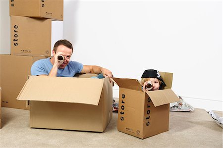 sitting inner tube - Father and son playing with moving boxes Stock Photo - Premium Royalty-Free, Code: 649-03667416