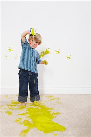 Toddler boy pouring paint onto carpet Stock Photo - Premium Royalty-Free, Code: 649-03667435