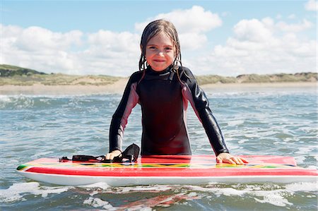 surfing - Young girl in the sea with surf board Foto de stock - Sin royalties Premium, Código: 649-03768914