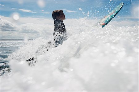 preteen sports - Young boy surfing through waves Foto de stock - Sin royalties Premium, Código: 649-03768919