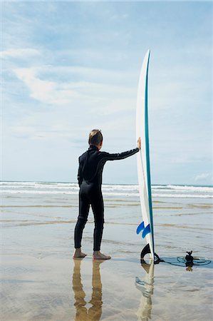 roupa molhada - Boy looking out to sea with surf board Foto de stock - Royalty Free Premium, Número: 649-03768928