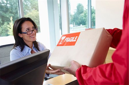 deliveryman woman - Businesswoman receiving a package Stock Photo - Premium Royalty-Free, Code: 649-03769462