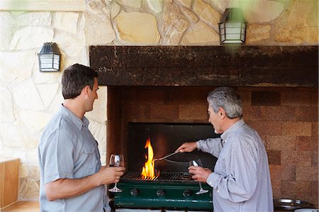 father and son cooking - Two men by barbeque holding wine glasses Stock Photo - Premium Royalty-Free, Code: 649-03769574