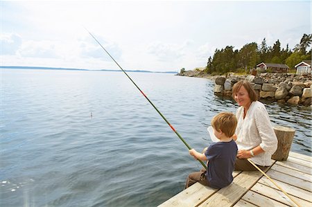 sitting on a jetty - Smiling grandmother watching fishing boy Stock Photo - Premium Royalty-Free, Code: 649-03769638