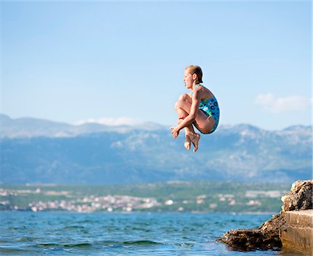 Girl jumping into water Stock Photo - Premium Royalty-Free, Code: 649-03769748