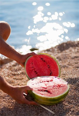 Man cutting watermelon at the beach Stock Photo - Premium Royalty-Free, Code: 649-03769751