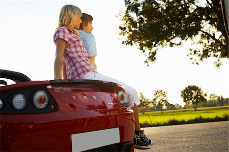 Couple sitting on their electric car Stock Photo - Premium Royalty-Free, Code: 649-03769994