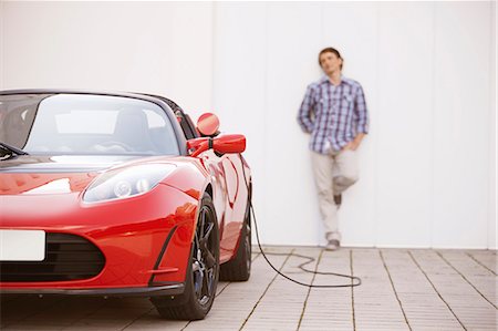 sustainable transportation - Young man filling up his electric car Stock Photo - Premium Royalty-Free, Code: 649-03762516