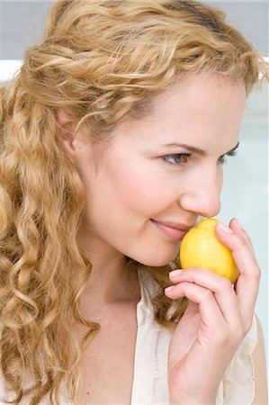 Woman smelling on lemon Foto de stock - Royalty Free Premium, Número: 649-03774014