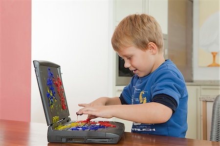 finger painting - Boy playing with paint on laptop Stock Photo - Premium Royalty-Free, Code: 649-03774402