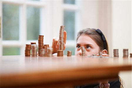 stacks of money and coins - Girl counting piles of money Stock Photo - Premium Royalty-Free, Code: 649-03774573