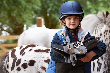 Jeune fille tenant une selle avec des poneys Photographie de stock - Premium Libres de Droits, Code: 649-03774610