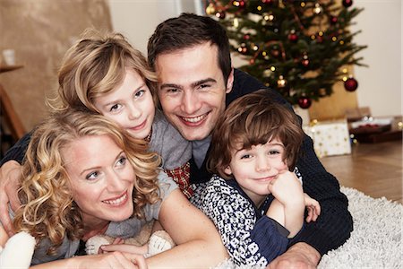 family holiday celebration - Couché sur le tapis devant l'arbre de famille Photographie de stock - Premium Libres de Droits, Code: 649-03774866