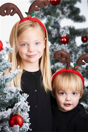 Brother and sister by the christmas tree Foto de stock - Sin royalties Premium, Código: 649-03775099