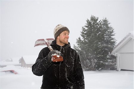 Homme debout avec pelle à neige sur sholder Photographie de stock - Premium Libres de Droits, Code: 649-03775216