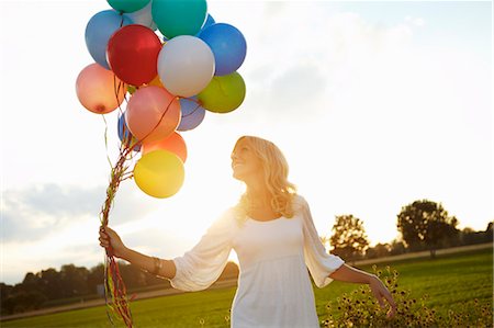 simsearch:649-06532681,k - Girl with balloons outside at sunset Foto de stock - Sin royalties Premium, Código: 649-03770001