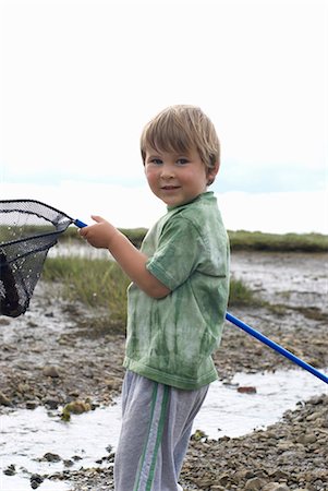 Young boy holding fishing net up Foto de stock - Sin royalties Premium, Código: 649-03770446