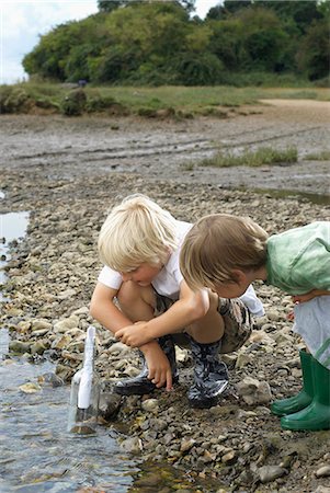 simsearch:6122-08229458,k - Two boys finding a message in a bottle Foto de stock - Royalty Free Premium, Número: 649-03770448