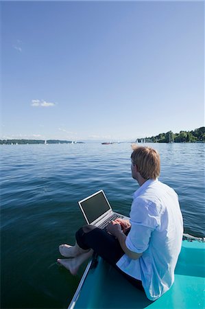 summer red - Man sitting with laptop by a lake Foto de stock - Sin royalties Premium, Código: 649-03770465