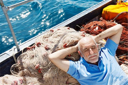 people and fishing boat and net - Fisherman asleep on nets Stock Photo - Premium Royalty-Free, Code: 649-03770748