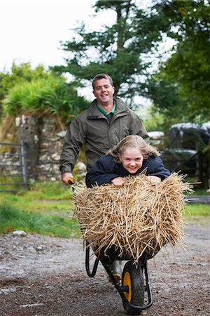 farm and father - Girl being pushed in wheel barrow Stock Photo - Premium Royalty-Free, Code: 649-03770866