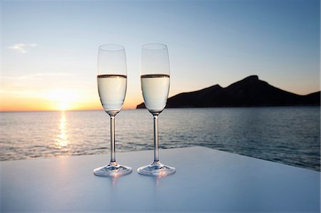 Champagne glasses shot against a sunset Stock Photo - Premium Royalty-Free, Code: 649-03771354