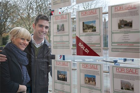 Couple looking into estate agents window Stock Photo - Premium Royalty-Free, Code: 649-03773107
