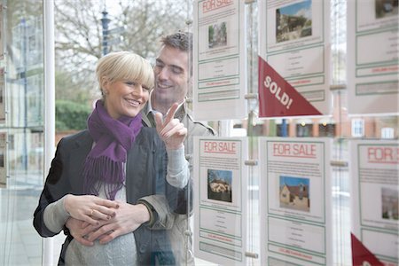 Couple à la recherche dans la fenêtre des agents immobiliers Photographie de stock - Premium Libres de Droits, Code: 649-03773109