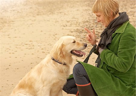 simsearch:649-09207273,k - Woman training dog on beach Autumn Fall Fotografie stock - Premium Royalty-Free, Codice: 649-03773170