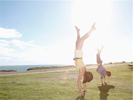 family outdoors blue sky - Mother and son doing hand stands Stock Photo - Premium Royalty-Free, Code: 649-03773283