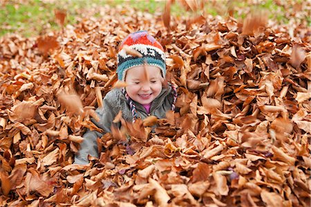 Girl playing in the leaves Stock Photo - Premium Royalty-Free, Code: 649-03773975