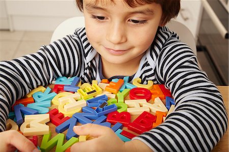 Boy playing with letters in kitchen Foto de stock - Sin royalties Premium, Código: 649-03796104