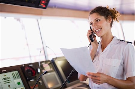 sala de controle - Mate of a ship doing a phone call Foto de stock - Royalty Free Premium, Número: 649-03796325