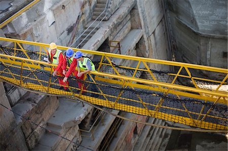 simsearch:695-03377910,k - Workers going over bridge in dockyard Fotografie stock - Premium Royalty-Free, Codice: 649-03796385