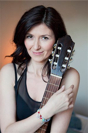 photograph guitar acoustic - Woman holding a guitar Stock Photo - Premium Royalty-Free, Code: 649-03796582