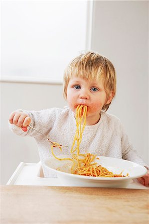 Messy baby boy eating spaghetti Foto de stock - Sin royalties Premium, Código: 649-03796941