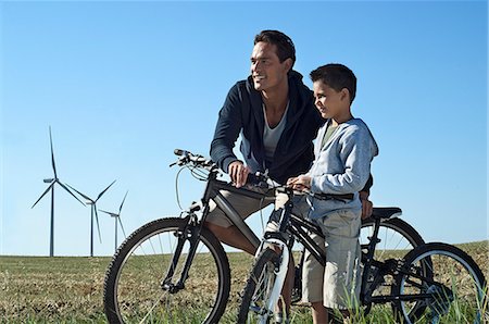 Father and son with bikes by a windfarm Foto de stock - Sin royalties Premium, Código: 649-03797046