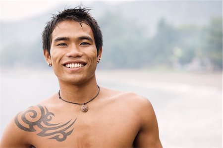 Guy with tatoo smiling to camera Foto de stock - Sin royalties Premium, Código: 649-03797443