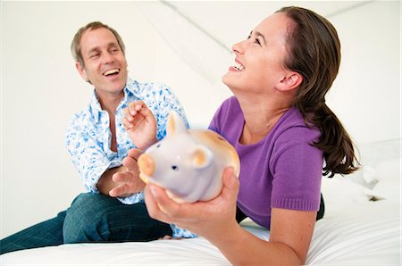 piggy bank and smiling - Couple fight over piggy bank Stock Photo - Premium Royalty-Free, Code: 649-03797652