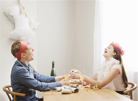 Couple pulling christmas crackers Stock Photo - Premium Royalty-Free, Code: 649-03817197