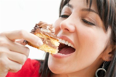 people eating desserts - Smiling woman eating chocolate cake Stock Photo - Premium Royalty-Free, Code: 649-03817411