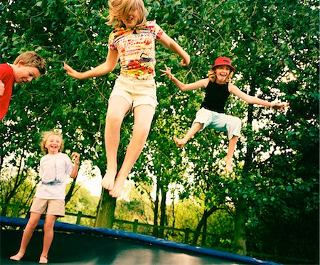 friends jumping outdoors - 4 children leaping on trampoline Stock Photo - Premium Royalty-Free, Code: 649-03817413