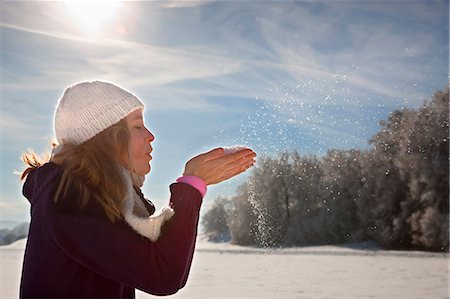 snow playing - Woman blowing snow from hands Stock Photo - Premium Royalty-Free, Code: 649-03817453