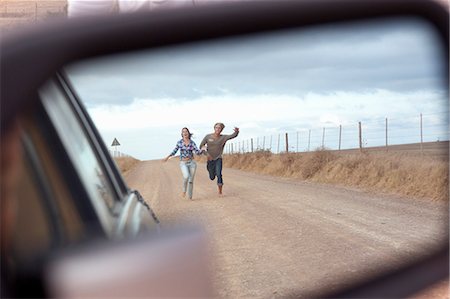 people walking away street - Couple running behind car Stock Photo - Premium Royalty-Free, Code: 649-03818247