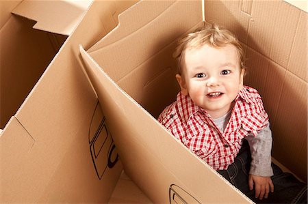 Little boy sitting in packing case Stock Photo - Premium Royalty-Free, Code: 649-03818268