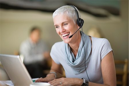 sales lady - Older woman in headset using laptop Stock Photo - Premium Royalty-Free, Code: 649-03857260